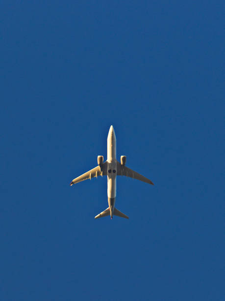 istock bottom view of jet liner flying at low altitude under a cloudless blue sky. 2181803761