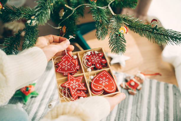 istock Hands holding festive ornaments by Christmas tree. 2181811270
