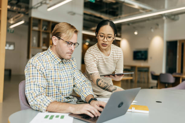 Two individuals collaborating on a business project in the office.