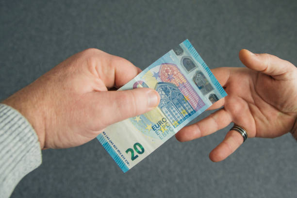 istock Cash payment. Twenty euros from hand to hand 2181814919