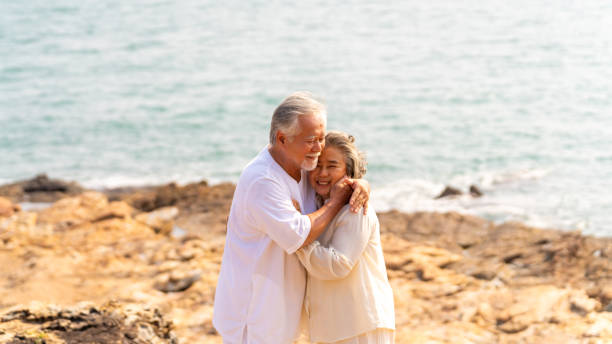 istock Asian senior couple relaxing on mountain cliff at summer sunset. 2181817669