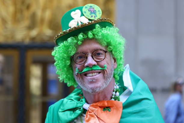 St. Patrick's Day. Beautiful smiling woman wearing green hat. Green background