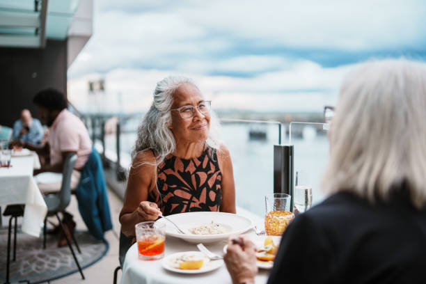 Pacific Islander senior woman having dinner with a friend