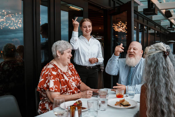 istock Deaf couple dining out with friends communicating with waitress using sign language 2181828678