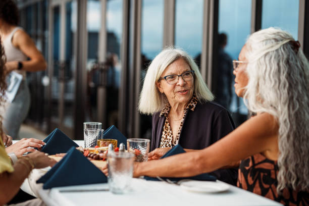 istock Senior woman having dinner with friends 2181828680