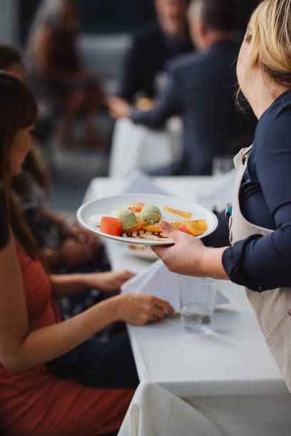 istock Waitress serving salads and starters to guests 2181828692