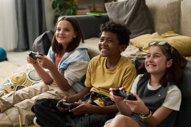 istock Smiling Children Playing Video Games Indoors on Couch 2181831531
