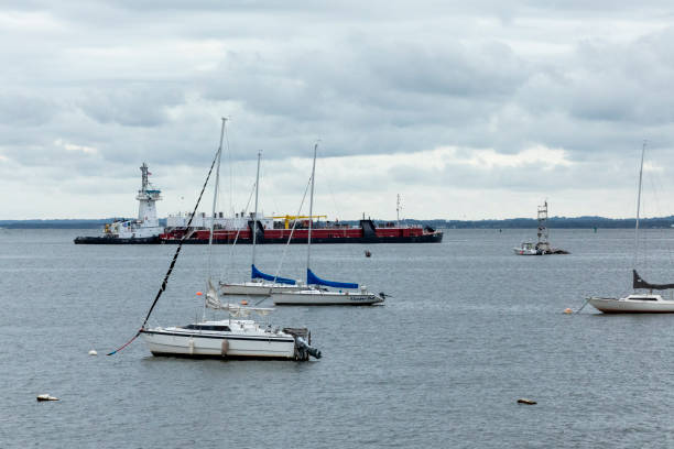 Aerial photo from a drone looking over to Felixstowe from Harwich with Tradewind Voyages' SV Golden Horizon sailing cruise ship in front.