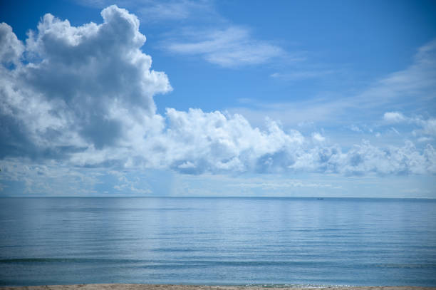 The blue sea with large white clouds in the sky as a background.