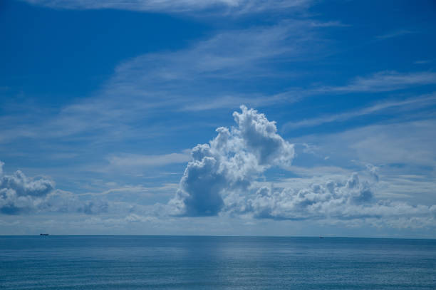 The blue sea with large white clouds in the sky as a background.