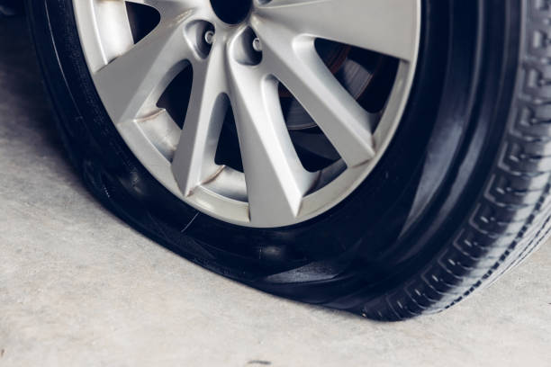 istock Destroyed blown out tire with exploded, shredded and damaged tire on a modern automobile. damaged truck rubber after tire explosion at high speed. Damaged flat tires: old car. 2181844211