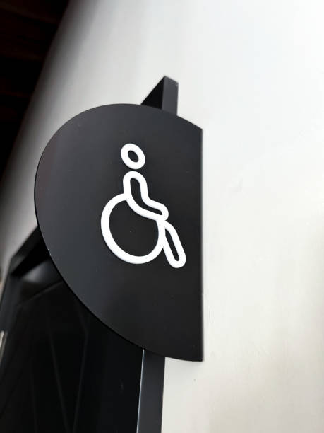 A clearly designed restroom sign features a symbol representing accessibility, specifically intended for individuals with disabilities. This sign is displayed prominently on a wall, ensuring that it is easily visible. The minimalist design uses contrasting colors to highlight the importance of inclusivity in public spaces.