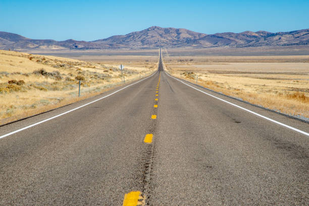 istock Empty road in the desert stretching to the horizon 2181849903