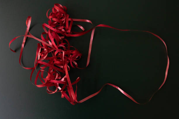 Red ribbon with gift bow on isolated white background. Top view, flat lay.