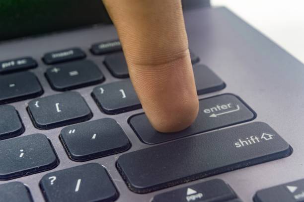 istock A finger pressing the enter key on a black laptop keyboard, isolated on a white background. Perfect for technology, productivity, 2181854317