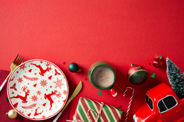 istock Christmas dinner concept. Flat lay Christmas table setting, gold cutlery, vintage gift box, cup of cacao drink, balls, decorations on red background. 2181854576