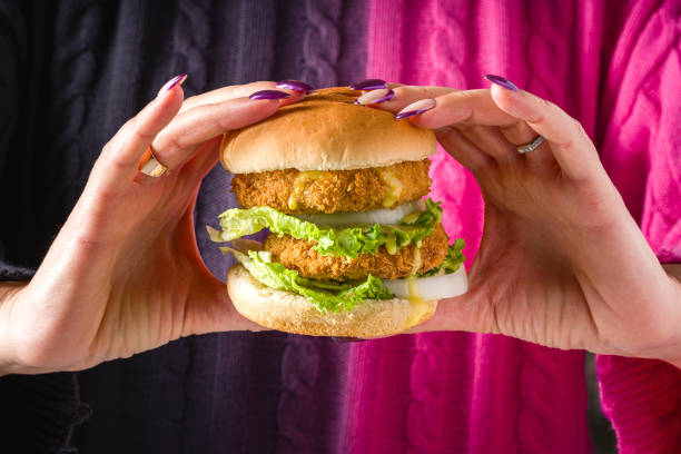 istock Woman holding fish or chicken burger with both hands 2181857889