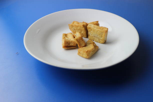 Fried tofu served on a plate on a blue background