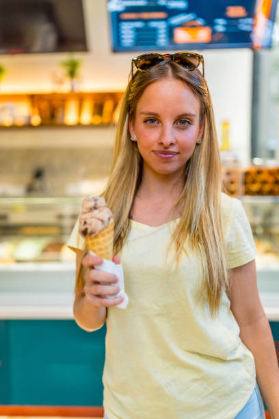 istock Blonde chic woman eating ice cream cone 2181859370