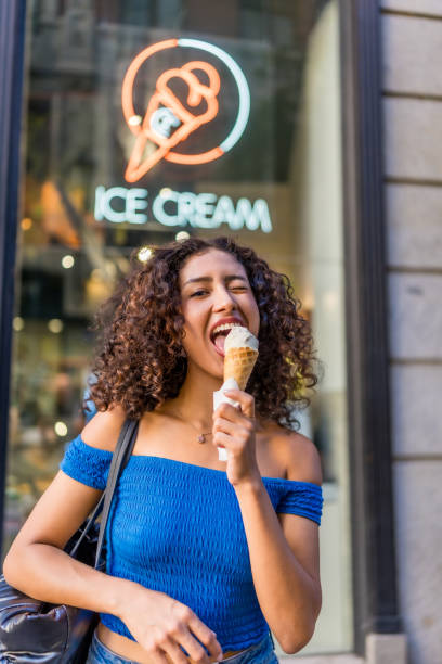 istock Friendly woman grimacing while eating ice cream outdoors 2181859407