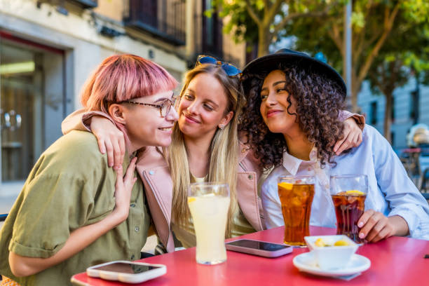 istock Cute friends embracing while drinking sodas and eat snacks outdoors 2181859461