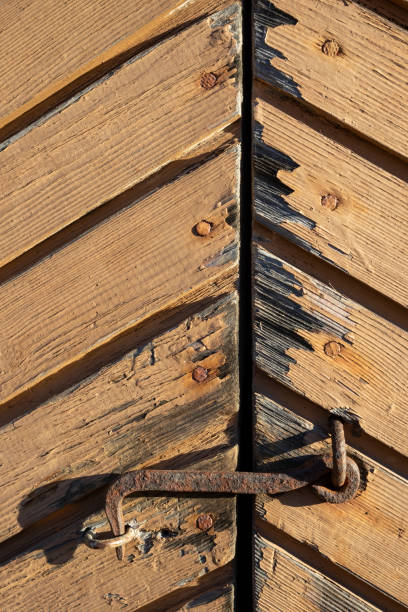 Rusty old hook latch on wooden door exterior