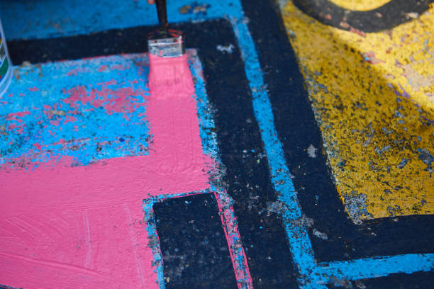 Workers are painting and renovating the playground surface to replace the old