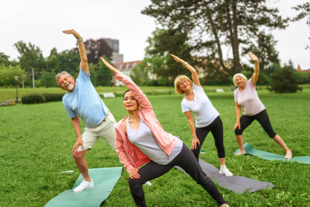 istock Senior Group Yoga Session in Park with Asian Instructor 2181860076