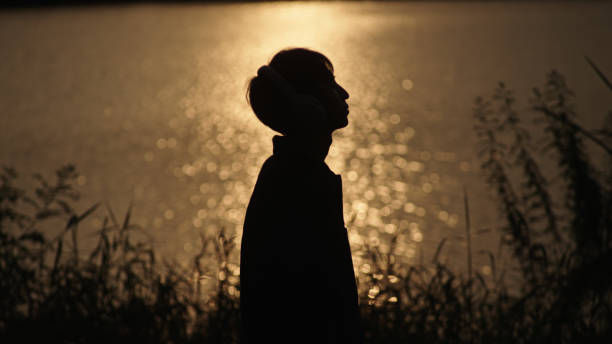 istock Man listening music at river side. 2181861558