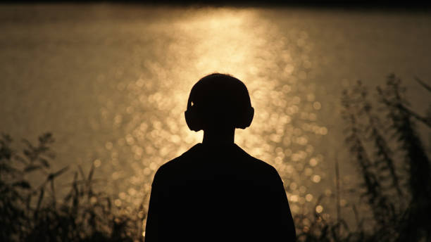 istock Man listening music at river side. 2181861577