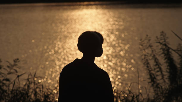 istock Man listening music at river side. 2181861580