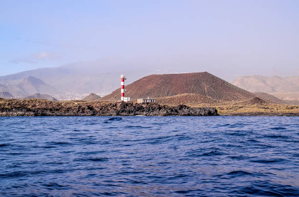 istock A lighthouse is on a rocky island in the ocean 2181863136