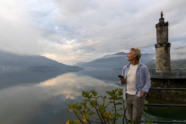 istock Mature man with mobile phone pauses on lakeshore 2181863915