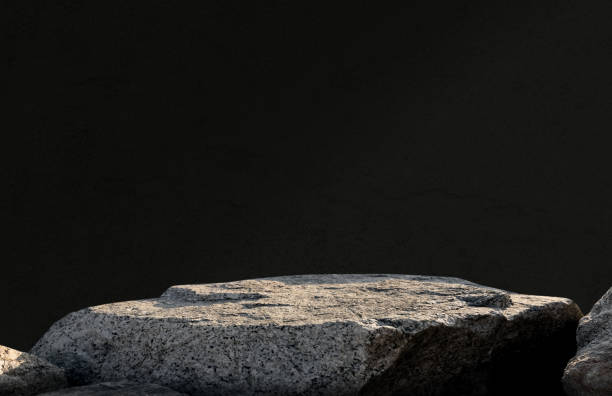 istock Stone Rock podium isolated on black wall background for product display presentation,Studio Background with Grey Sea Rock Shelf with rough surface texture with light,shadow on dark concrete background 2181870919