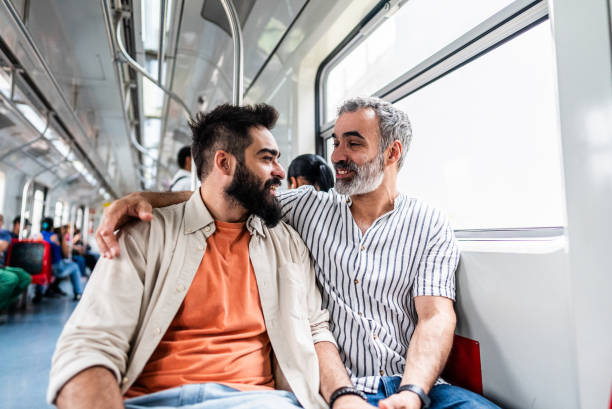 Gay couple talking inside subway train