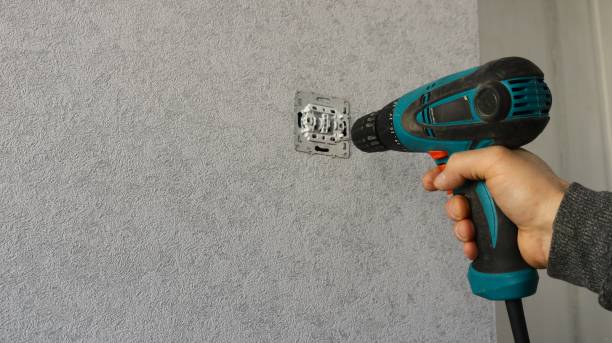 istock An employee repairs or maintains an light switch using a screwdriver 2181876187