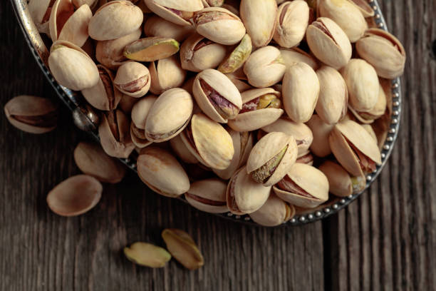istock Salted pistachios on an old wooden table. 2181876442