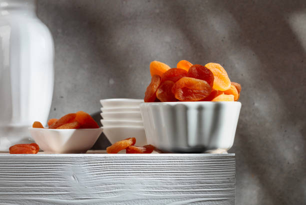Dried apricots on a white wooden table.
