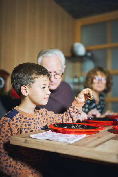 Young boy with family at dining table enjoying dessert