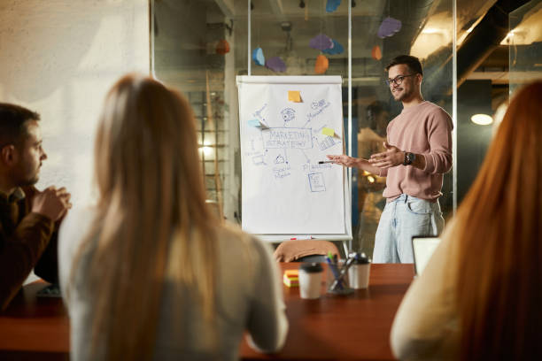 istock Happy freelancer talking to his colleagues on a presentation in the office. 2181879231
