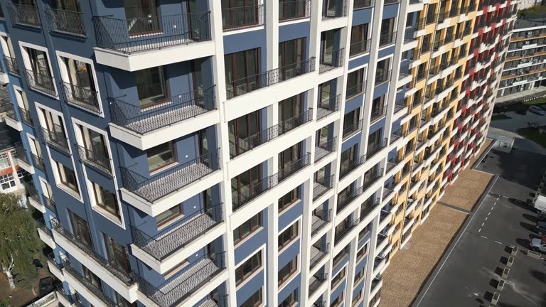 Aerial drone view of colorful residential buildings with unique architectural facades in blue, yellow, and red, showcasing modern urban design and city living in a vibrant cityscape