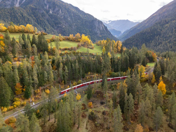istock Red Train Journeying Through Autumn Forest in Mountain Valley 2181883197