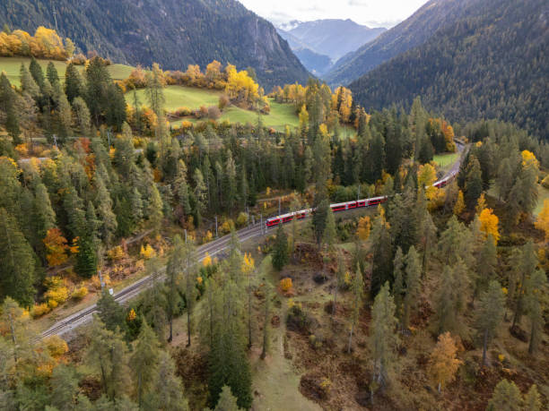 istock Red Train Journeying Through Autumn Forest in Mountain Valley 2181883199