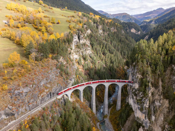 istock Red Train Crossing Scenic Viaduct Over Mountain Gorge in Autumn 2181883284