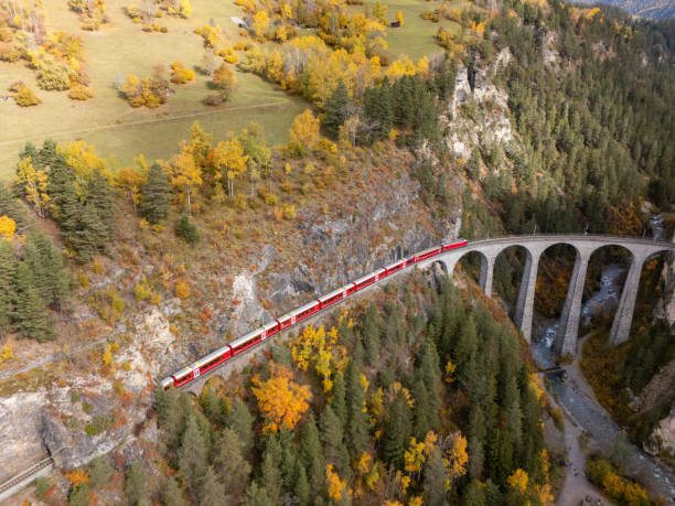 istock Red Train Crossing Scenic Viaduct Over Mountain Gorge in Autumn 2181883377