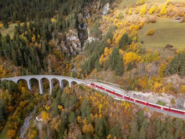 istock Red Train Crossing Scenic Viaduct Over Mountain Gorge in Autumn 2181883400