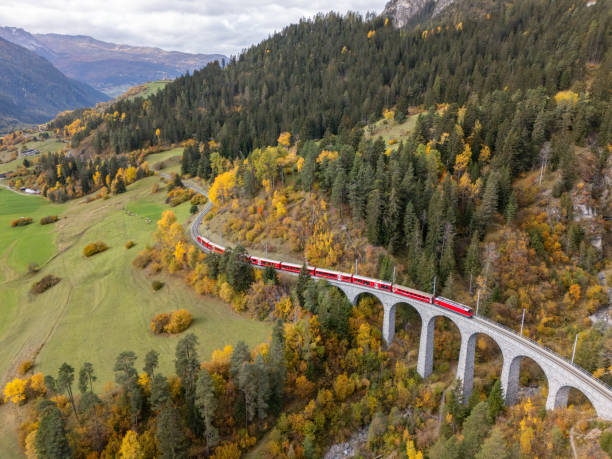 istock Red Train Crossing Scenic Viaduct Over Mountain Gorge in Autumn 2181883429