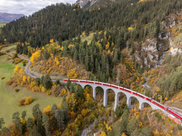 istock Red Train Crossing Scenic Viaduct Over Mountain Gorge in Autumn 2181883432