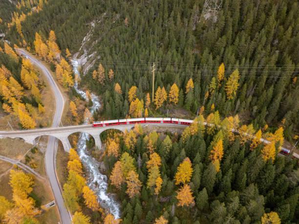 istock Red Train Crossing Bridge in Autumn Mountain Landscape 2181883685
