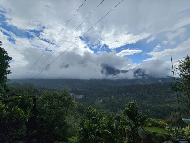 istock Misty mountains and lush greenery under cloudy skies. 2181883686